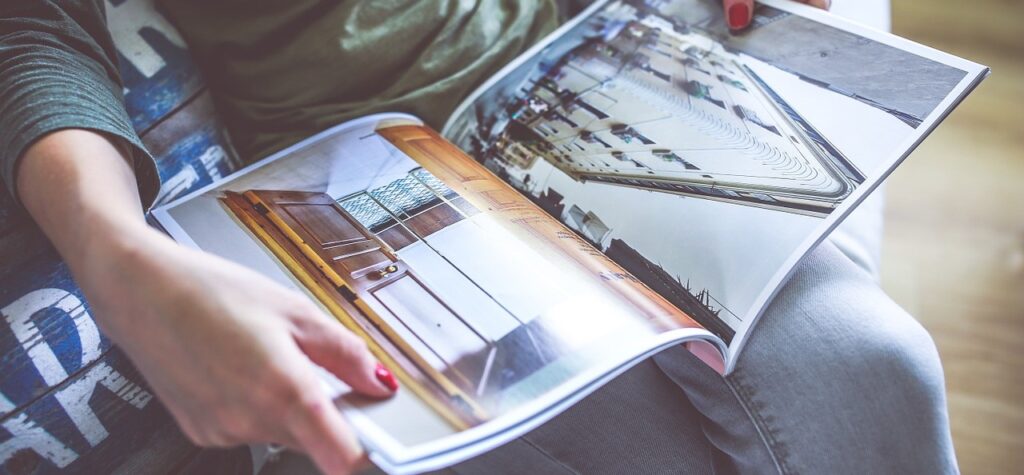 Frau schaut moderne Häuser in Katalog an